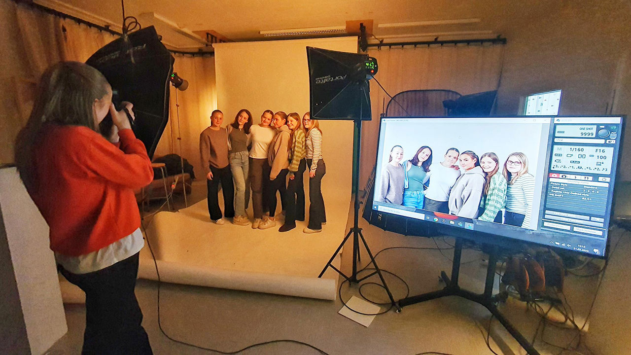 På bilete ser vi hospitantar som lærer å ta portrettfoto på fotostudioet.